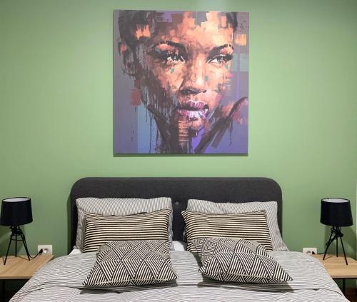 a painting above a bed with pillows in a bedroom at VilaA21 in Bar