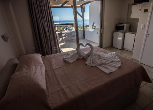 a bedroom with a bed with two swans on it at Kionia Panorama Studios in Kionia