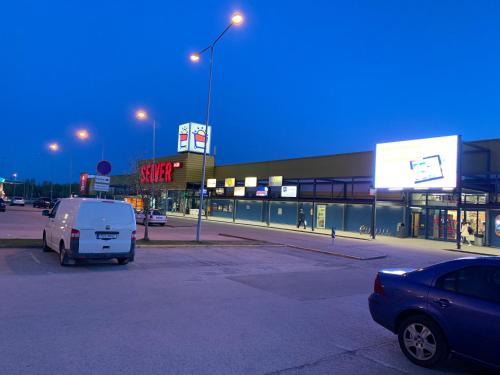 a car parked in a parking lot in front of a store at K84, Nice 2- bedroom apartment - 2 big beds 1 single bed in Tartu