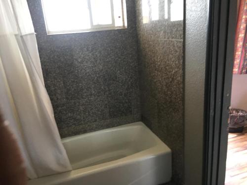 a bathroom with a bath tub and a window at Valley Motel in Atwater