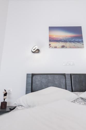 a bedroom with a bed and a picture on the wall at Akrogiali Apartments in Barbati