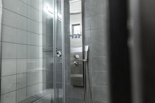 a shower in a bathroom with a glass door at Akrogiali Apartments in Barbati