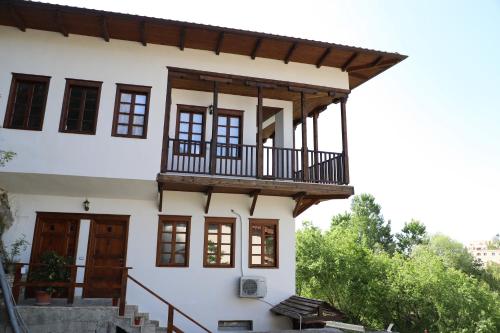 een huis met een balkon er bovenop bij Hotel Demaj in Berat