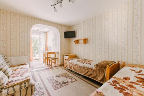 a bedroom with two beds and a chair and a window at Wędrowiec in Karwia