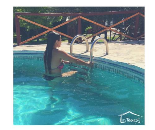 a woman in the water near a swimming pool at Complejo Turistico Los Troncos in San Rafael