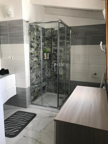 een douche met een glazen deur in de badkamer bij Casa da Bea in Gonnesa