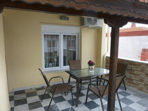 a patio with a table and chairs and a window at Dimitris appartment in Stavros