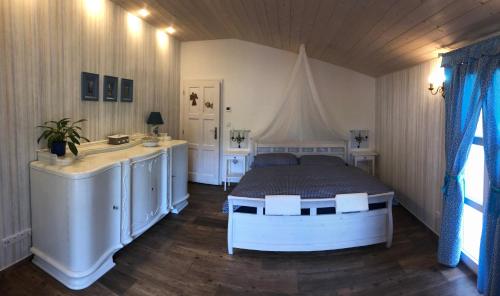 Schlafzimmer mit einem Bett, einer Badewanne und einem Waschbecken in der Unterkunft Penzion Primášé in Dolní Věstonice