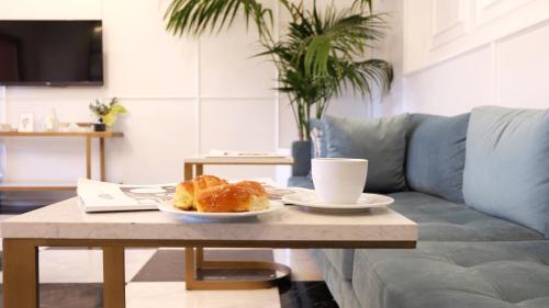 a coffee table with a plate of croissants and a cup of coffee at Akra V - Access to Akra Antalya in Antalya