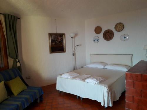 トッレ・デッレ・ステッレにあるVilla panoramica Torre delle Stelleのベッドルーム(白いベッド1台、ソファ付)