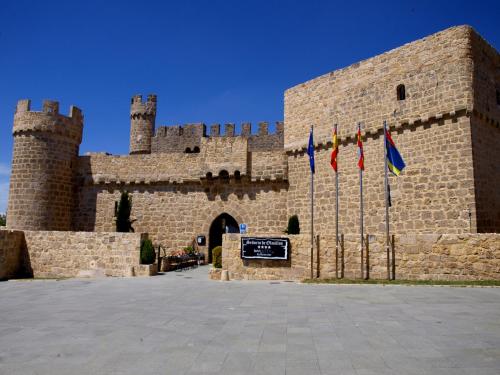 un gran castillo con banderas delante en Señorio de Olmillos, en Olmillos de Sasamón