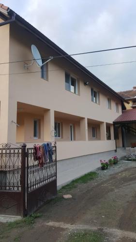 a building with a fence with clothes hanging on it at La Bustea in Hărţăgani