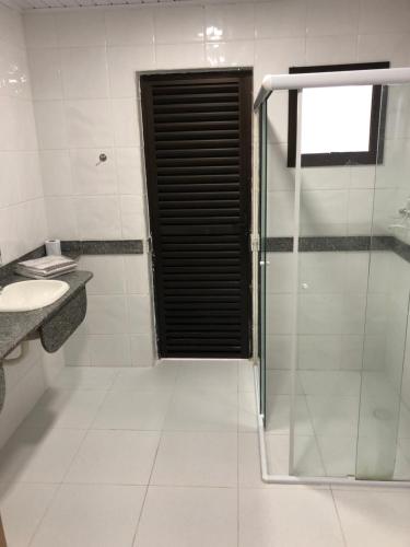 W łazience znajduje się szklana kabina prysznicowa i umywalka. w obiekcie Grand Hotel Taboao w mieście Taboão da Serra