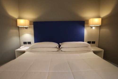 a bedroom with a large bed with two pillows at Hotel Umbria in Attigliano