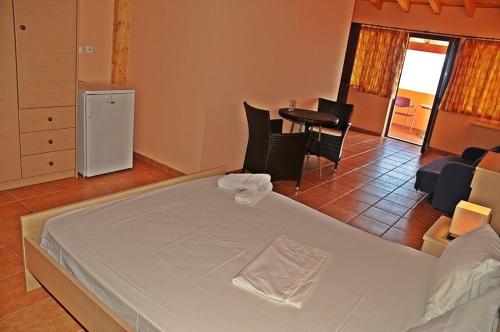 a bedroom with a white bed and a living room at Villa Eugenia in Theológos