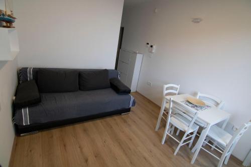 a living room with a couch and a table and chairs at Volcano Rijeka in Rijeka