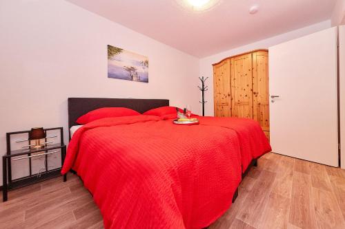 a bedroom with a red bed and a wooden door at Alte Brauerei in Bernkastel-Kues