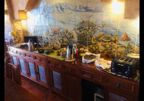 a kitchen with a counter with a painting on the wall at Casa Estrella de la Valenciana Hotel Boutique in Guanajuato