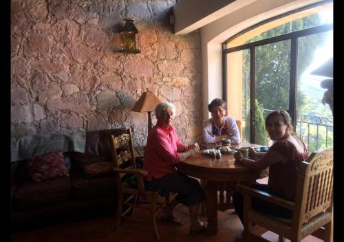 a group of people sitting around a wooden table at Casa Estrella de la Valenciana Hotel Boutique in Guanajuato