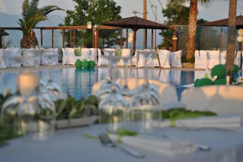 a table with white chairs and a table with wine glasses at Villa Eugenia in Theológos