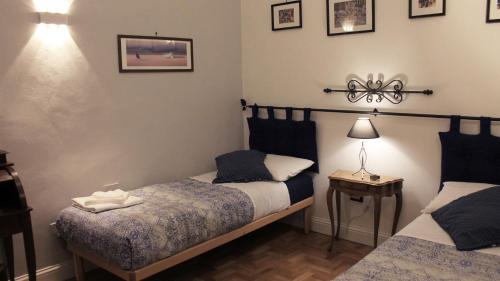 a bedroom with two beds and a table with a lamp at Duomo Classic Apartment in Florence