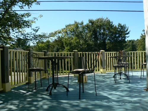 a patio with chairs and a table and a fence at Auberge de la Tour et Spa in Magog-Orford