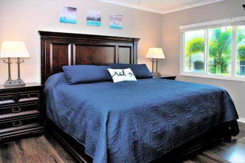 a bedroom with a blue bed and two lamps at Beach Getaway - Ocean beach, tennis, golf, pool with tiki bar in Fort Pierce