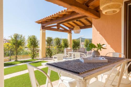 a patio with a table and chairs on a yard at Villa Amelia in Villasimius