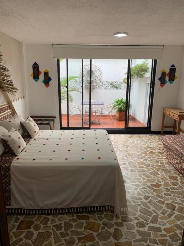 a bedroom with a bed and a view of a patio at Hotel Zandu in Pereira