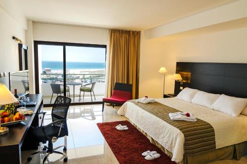 a hotel room with a bed and a desk and a balcony at Hotel Balandra in Manta