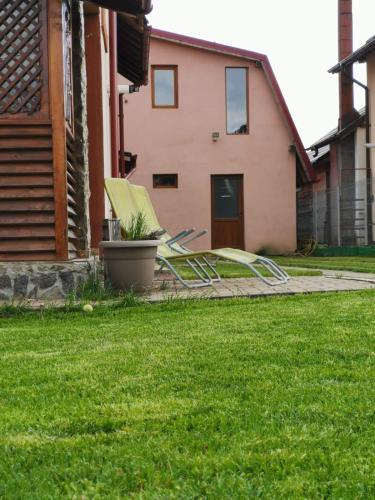a couple of lawn chairs sitting in a yard at Vila de vacanta Curtea de Arges in Curtea de Argeş