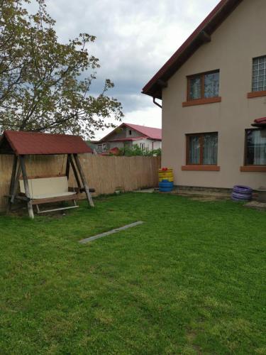 a yard with a gazebo and a house at Vila de vacanta Curtea de Arges in Curtea de Argeş