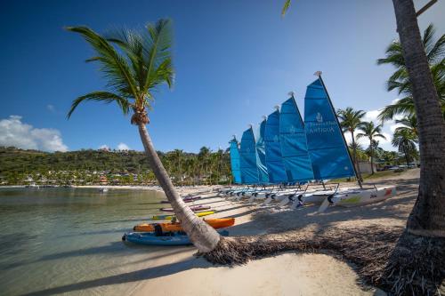 a group of boats on a beach with palm trees at St. James's Club Resort - All Inclusive in English Harbour Town