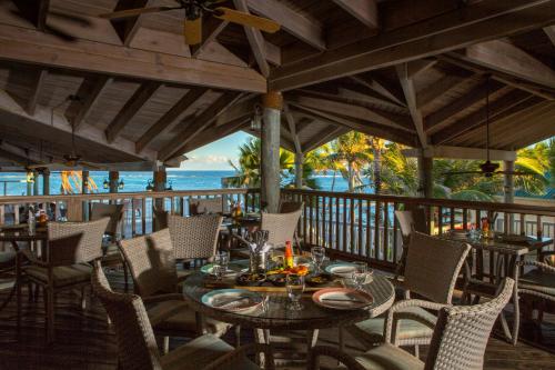 um restaurante com uma mesa e cadeiras num deque em St. James's Club Resort - All Inclusive em English Harbour Town