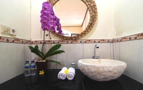 um banheiro com uma pia e um espelho em Arik's Homestay Ubud em Ubud