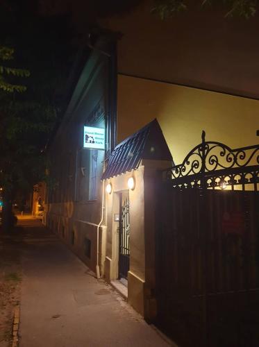 a building with a gate and a sign on it at night at Guest House Orczy Park in Budapest