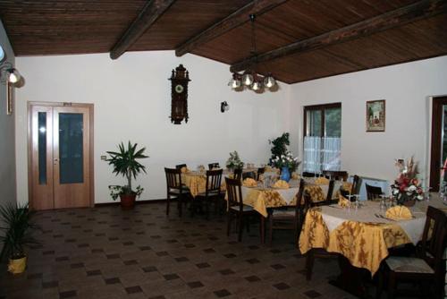 a dining room with tables and chairs and a clock at Agriturismo La Botte in Fragneto Monforte