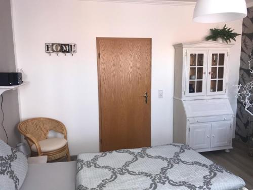 a bedroom with a bed and a cabinet and a door at Ferienwohnung am Schlossparkcenter in Schwerin
