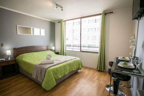 - une chambre avec un lit vert et une grande fenêtre dans l'établissement Apartments Zenteno, à Santiago