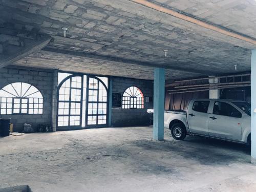 a white van parked in a garage with windows at Hostal Chasqui in Otavalo