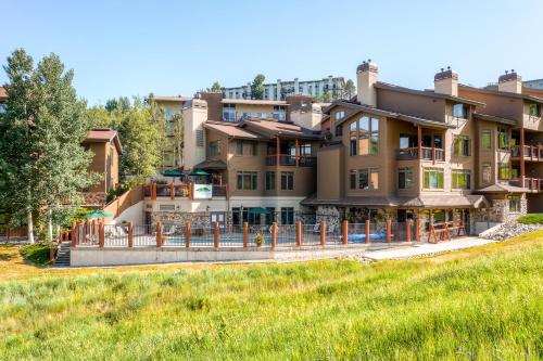 Un gran edificio en una colina con un campo verde. en Christie Club, en Steamboat Springs