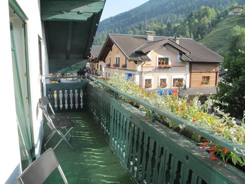 a balcony with a view of a house and mountains at Flasch Appart-Pension in Wagrain