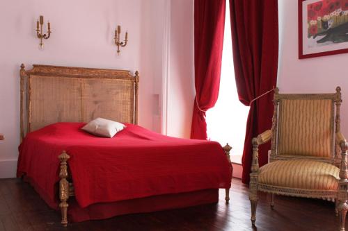 a bedroom with a red bed and a chair at Résidence et Chambres d'Hôtes de La Porte d'Arras in Douai