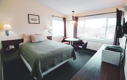 ein Hotelzimmer mit einem Bett und einem Fenster in der Unterkunft Kings Landing in Homer