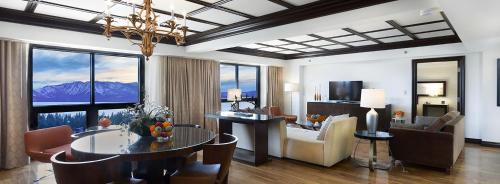 a living room with a dining table and a living room with mountains at Bally's Lake Tahoe Casino Resort in Stateline