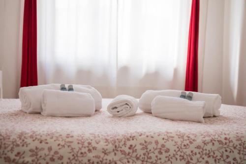 a group of towels on top of a bed at B&B Cento Passi Dalle Mura in Lucca