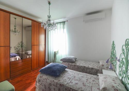 a bedroom with two beds and a mirror at Le Palme Trieste in Trieste