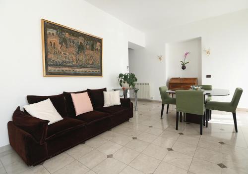 sala de estar con sofá marrón y mesa en Le Palme Trieste en Trieste