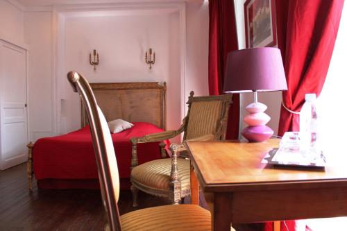 a room with a table and chairs and a bed at Résidence et Chambres d'Hôtes de La Porte d'Arras in Douai