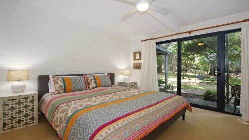 a bedroom with a bed and a large window at Bright River Rest in Bright